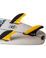 The FCS FCS II Mick Fanning PC Tri Surfboard Fins in Black & Mango